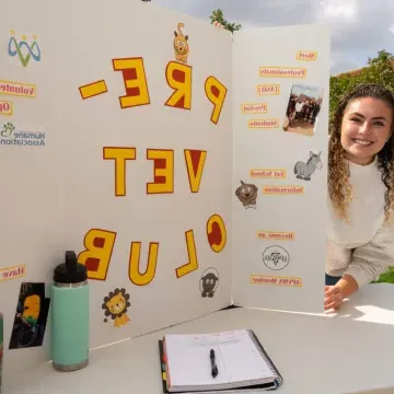 Female student at student org fest 为 Pre-Vet club table